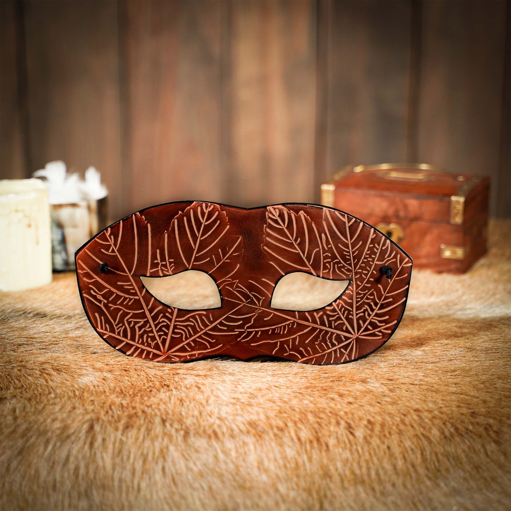 Antifaz marrón en piel con motivos de hojas de arce en relieve